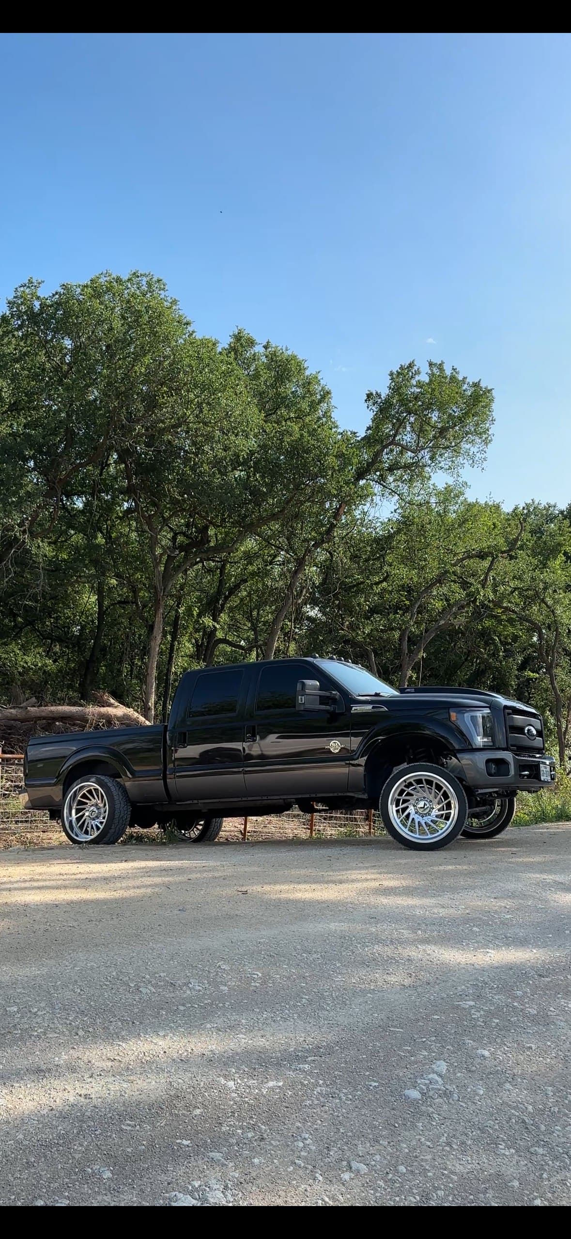 Lifted black Ford F-250 on custom wheels, built by 2 Man Fab