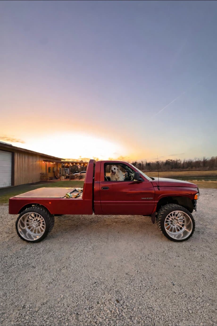 Custom flatbed dually build finished by 2 Man Fab, parked outside the Little Elm shop at sunset
